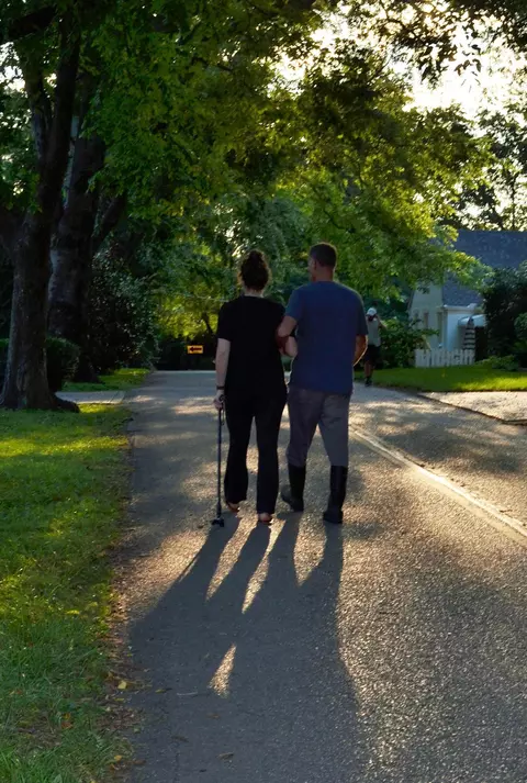 Two People Walking On Road