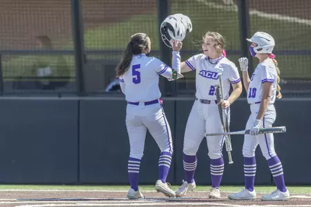 Shaylee Alani congratulated by teammates at home plate after hitting a homerun against UCA