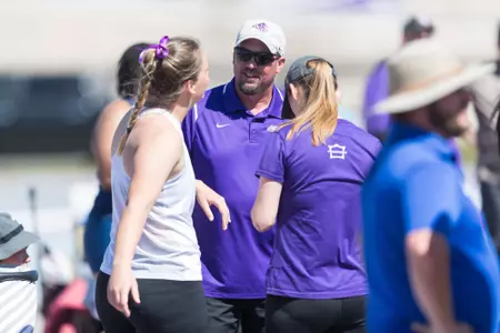 Track and field head coach Jerrod Cook confers with his student-athletes at a 2021 meet.