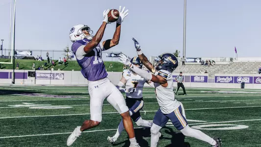 Blayne Taylor jumps to catch a pass over two Northern Arizona defenders on Nov 30, 2024