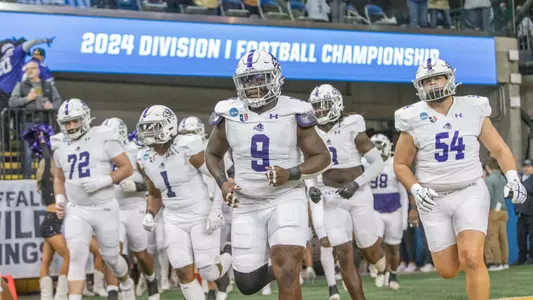 ACU football team runs onto the field at the Fargodome against North Dakota State