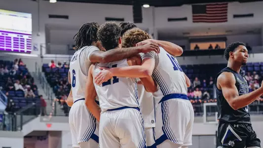 Men's basketball huddles together vs Stephen F Austin on December 31, 2024