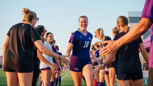 Emma Taylor runs through a tunnel of teammates before a game in October 2025