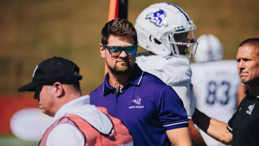 Trainer Tyler Lowe looks on during ACU's football game at West Georgia