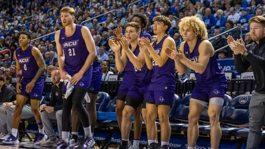 ACU men's basketball players cheer on their teammates during a game at BYU on December 19, 2025
