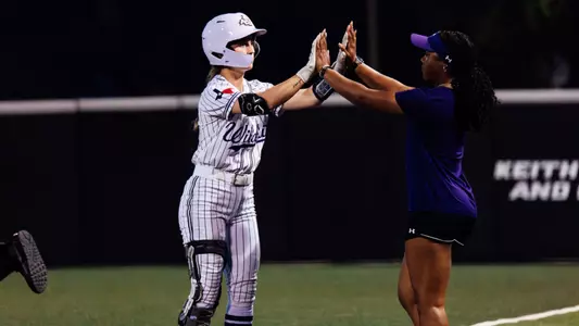 Emalee Romero gives a high-10 with graduate assistant Alyssa Woods after reaching first base.