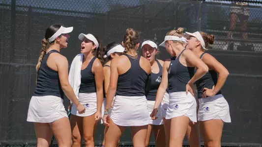 ACU women's tennis team cheers before a match in spring 2025
