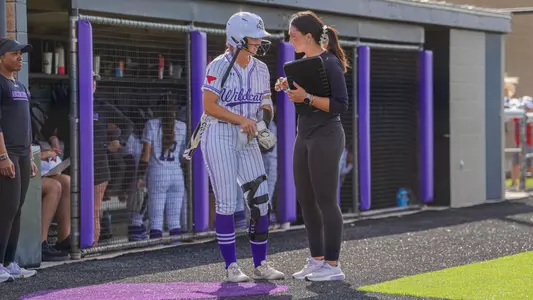 Softball coach Lexi Wagner talks to a player before an at-bat on March 29, 2025