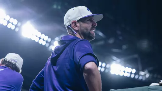 ACU baseball coach Rick McCarty smiles in the dugout during a game at Globe Life Park in 2025