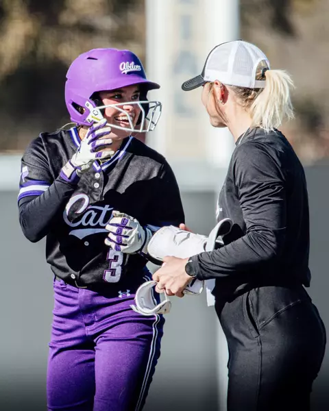 Ciana Arguijo celebrates reaching first base with assistant coach Campbell Hutcherson