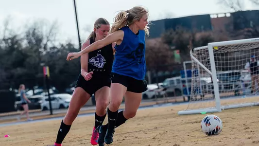 Chaney Maurer and Baylie Simon compete for a ball during an ACU soccer practice at Elmer Gray Stadium on Feb. 12, 2026.