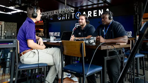 Luke Roaten and Kortlin Rausaw are interviewed by Evan Nemec during the UAC Football Kickoff on July 21, 2026 in Arlington, Texas