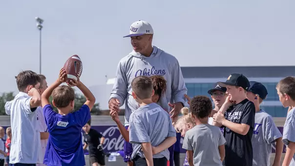 Joel Filani talks with campers at a youth football camp put on by ACU.