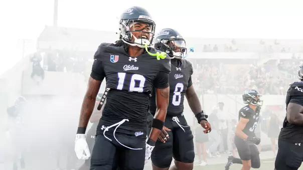 MJ Harrell (left) and Alex Bowman Jr. (center) run onto the field before ACU's game against Stephen F. Austin on Sept. 12, 2026