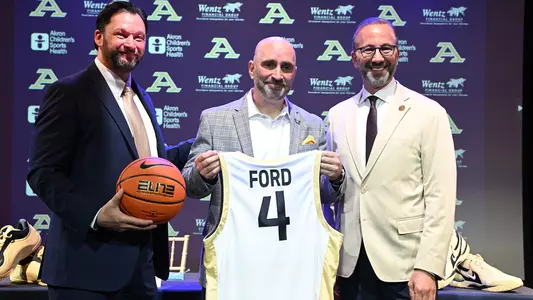 Photo showing Dr. Andrew T. Goodrich, Dustin Ford and Akron President RJ Nemer introducing Dustin Ford as the new Head Men's Basketball Coach