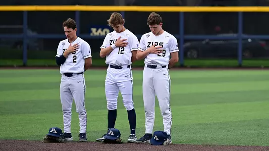 Photo showing three Akron Zips before a game against YSU