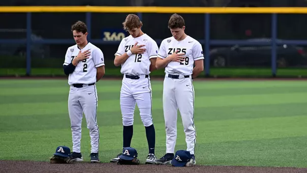 Photo showing three Akron Zips before a game against YSU