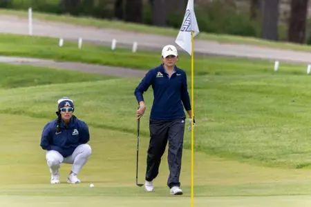 Kaitlin Kormuth approaces green, Coach King checking the line