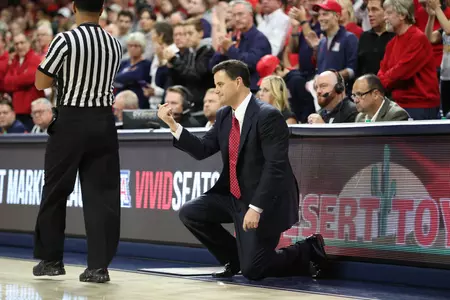 Coach Sean Miller kneels on the sideline during UA's game versus Northern Colorado