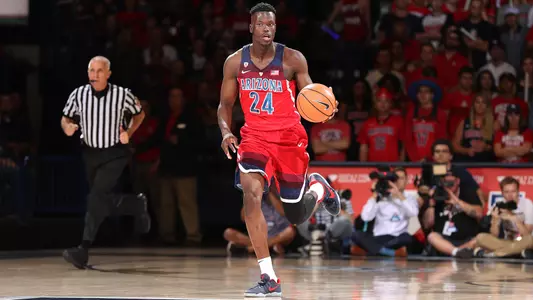 Emmanuel Akot dribbles the ball inside McKale Center