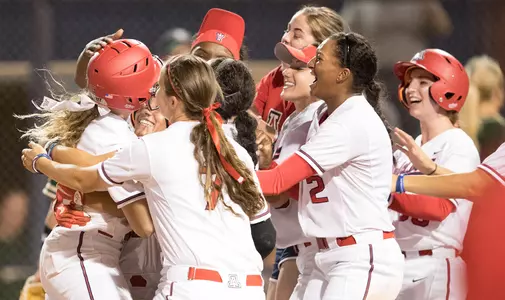 Arizona celebrates at home plate after Jessie Harper's walk-off single versus Bayloyr