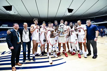 Arizona celebrates with the trophy of the 2019 Wooden Legacy