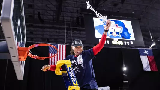 Adia Barnes holds up the net after Arizona's 2021 Elite Eight win over Indiana