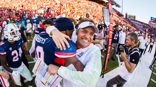 Jedd Fisch hugs Jerry Roberts after winning the 2022 Territorial Cup