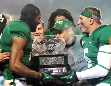 Baylor head coach Art Briles kissing the 2013 Big 12 Championship trophy.