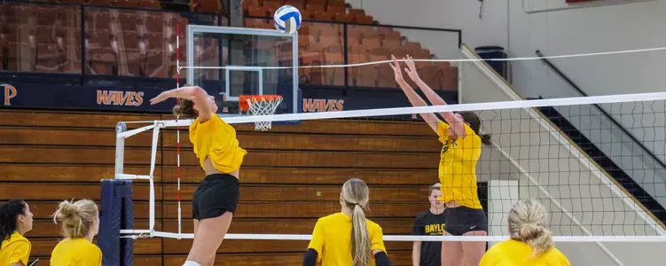 Kara McGhee goes up for the kill over Alicia Andrew in practice at Pepperdine
