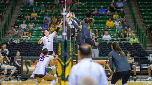 Alicia Andrew and Averi Carlson go up for a block against Evansville.