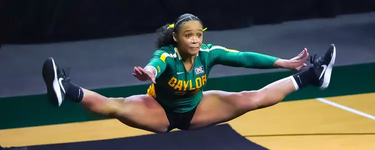 Mariah Polk does a toe touch in compulsory tumbling against Presbyterian