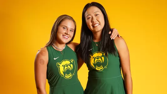 Zuzanna Kubacha and Na Dong post in front of gold background