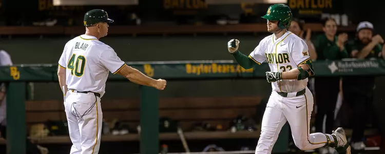 Wesley Jordan fist bumping Jim Blair after a home run against LMU in 2025