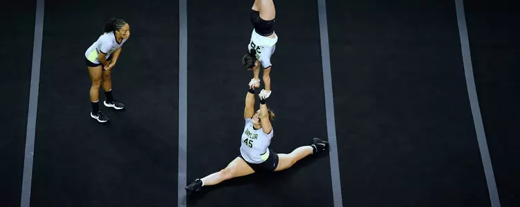 Jordan Gruendler in a straight handstand while Leavy McDonald is in a straight slide to split.