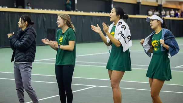 Women's Tennis athletes cheering courtside vs Rice