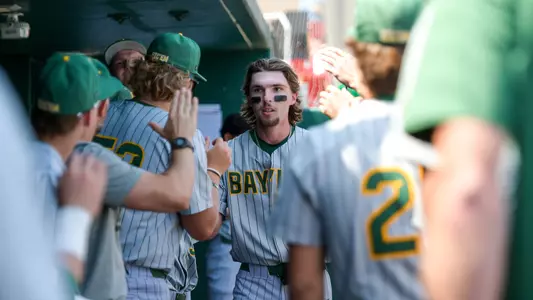 Travis Sanders high fives his teammates in the dugout at Houston 2026
