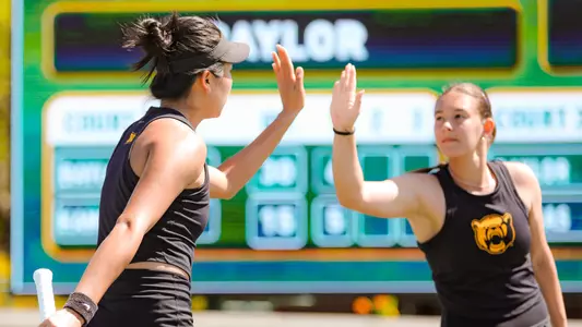 Na Dong and Alian Zack high five in doubles vs Kansas at Hurd Tennis Center