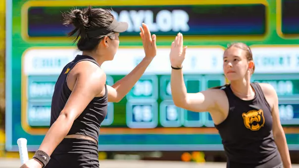 Na Dong and Alian Zack high five in doubles vs Kansas at Hurd Tennis Center