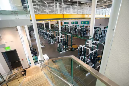 Interior photos of the Fudge Football Development Center weight room with racks of weights, dumbbells, squat racks, etc.