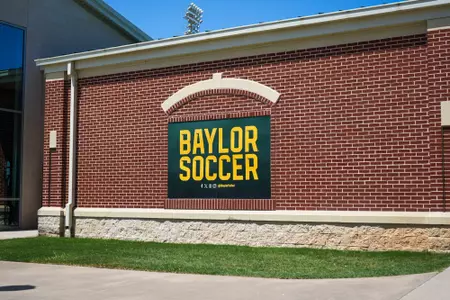 Facility photos of Betty Lou Mays Field; updated signage in 2026 features 2025 Sweet 16 and Tyler Isgrig All-America accolades