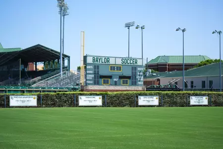 Facility photos of Betty Lou Mays Field; updated signage in 2026 features 2025 Sweet 16 and Tyler Isgrig All-America accolades