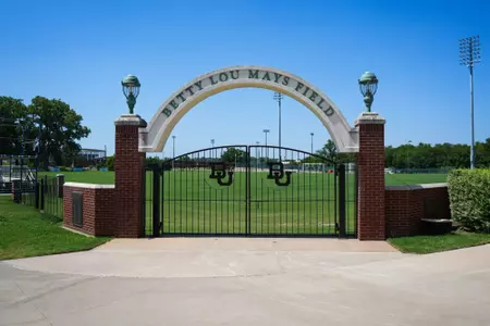 Facility photos of Betty Lou Mays Field; updated signage in 2026 features 2025 Sweet 16 and Tyler Isgrig All-America accolades