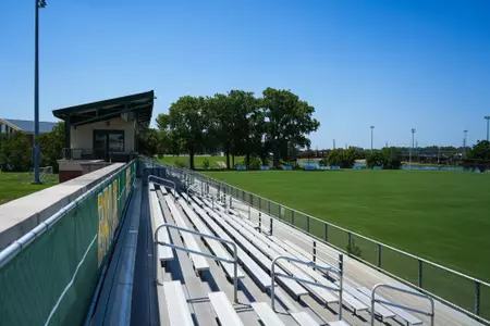 Facility photos of Betty Lou Mays Field; updated signage in 2026 features 2025 Sweet 16 and Tyler Isgrig All-America accolades