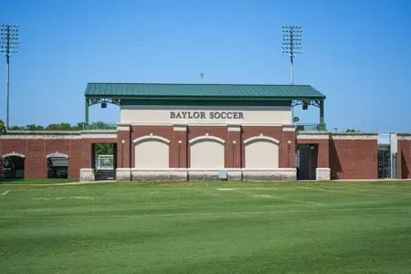 Facility photos of Betty Lou Mays Field; updated signage in 2026 features 2025 Sweet 16 and Tyler Isgrig All-America accolades