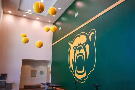 Exterior and interior photo of Hawkins Indoor Tennis Center in 2026, showcasing the outside entrance, courts, lobby and seating areas