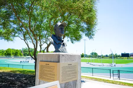 Exterior photos for Clyde Hart Track & Field Stadium in 2026, including the track, grandstands, buildings and Clyde Hart bust