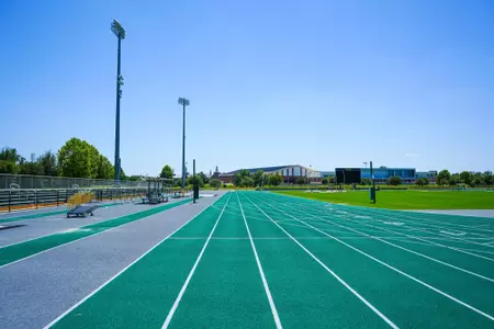 Exterior photos for Clyde Hart Track & Field Stadium in 2026, including the track, grandstands, buildings and Clyde Hart bust