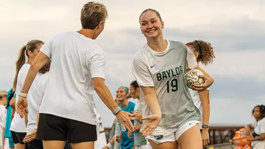 Bella James high fives Coach Lenard in starting introductions