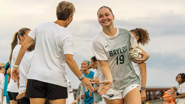 Bella James high fives Coach Lenard in starting introductions